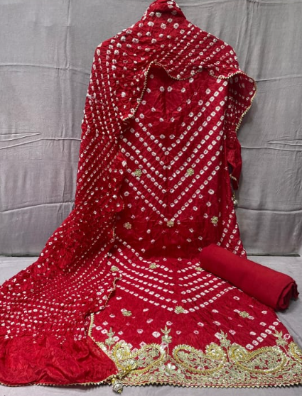 Red embroidered fabric with gold patterns on a gray background