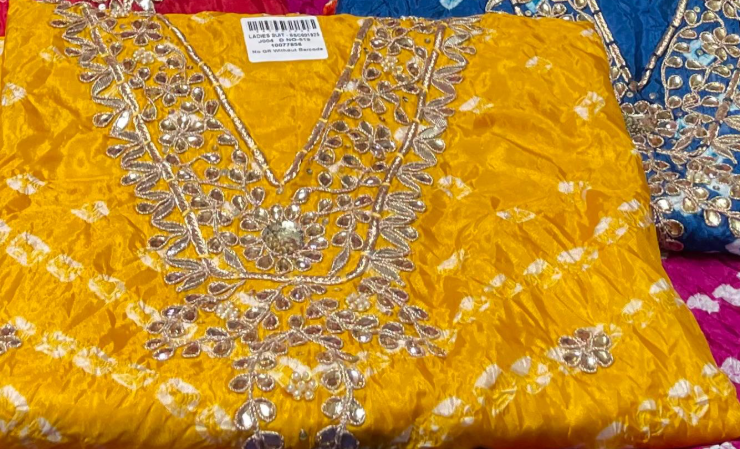 Yellow fabric with intricate silver embroidery on a colorful background