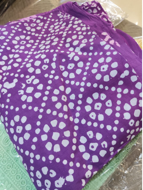 Purple fabric with white pattern on a green surface
