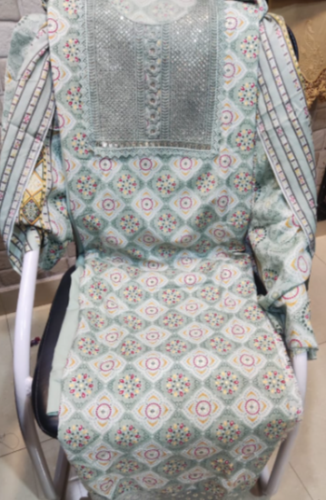 Patterned baby bouncer with floral and geometric designs on a neutral background